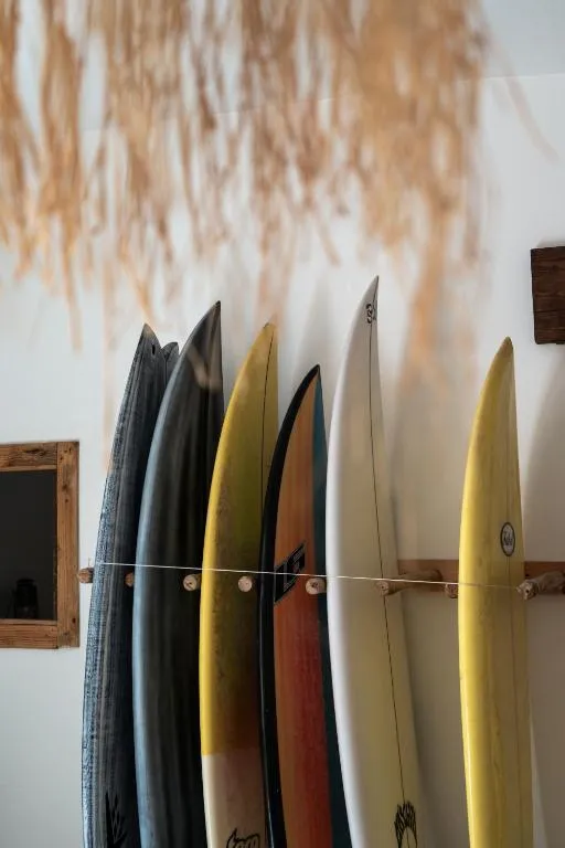 Boards racked inside the Morocco Surf Club lodge in Tamraght — equipment is included on every camp week