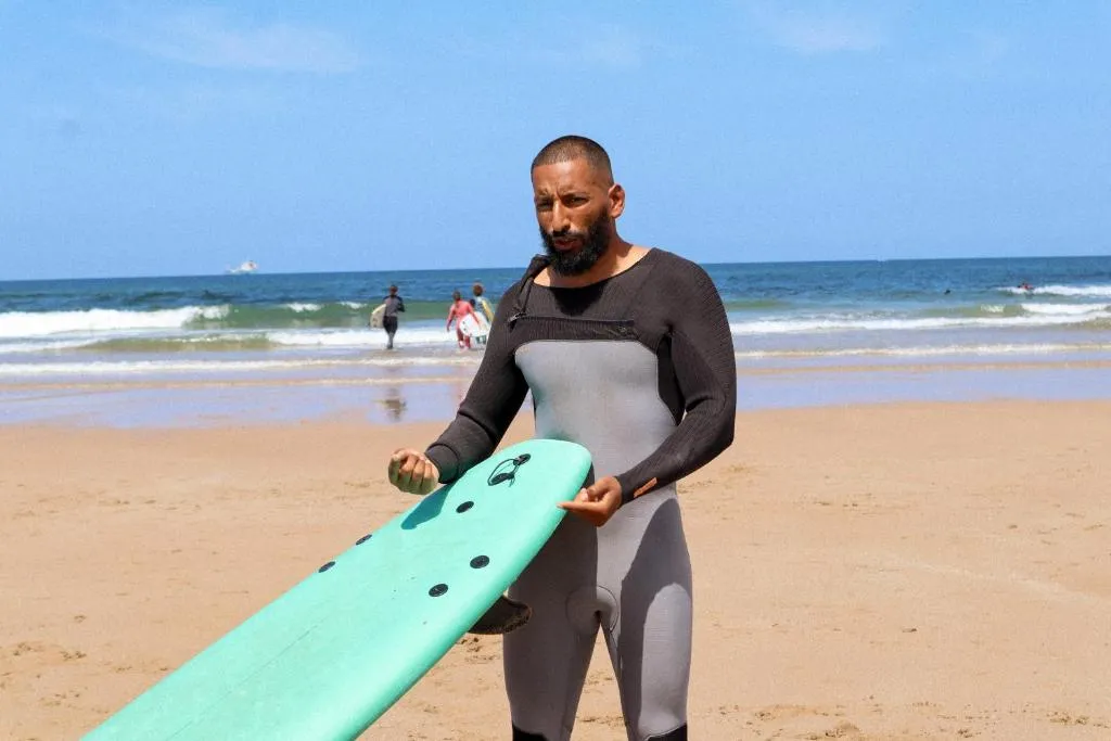 Jamal explaining a wave selection to a Morocco Surf Club guest on the beach