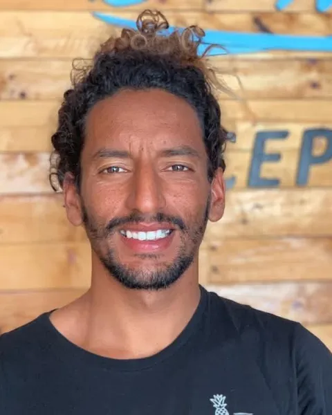 Jamal, lead surf coach at Morocco Surf Club, on the beach in Taghazout Bay